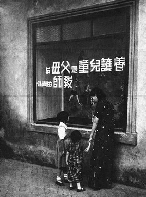 7.1936年，江蘇鎮(zhèn)江民眾教育館的宣傳櫥窗前，一位母親正在給兩個(gè)女童講解。吳寅伯?dāng)z。（原載《老照片》第12輯）.jpg