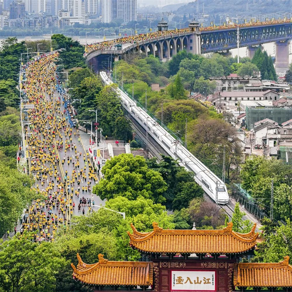 齊頭并進(jìn) 姜濤 攝2019年4月14日，參加馬拉松比賽的選手們經(jīng)過(guò)武漢長(zhǎng)江大橋，與動(dòng)車同行，與黃鶴樓同框。.jpg